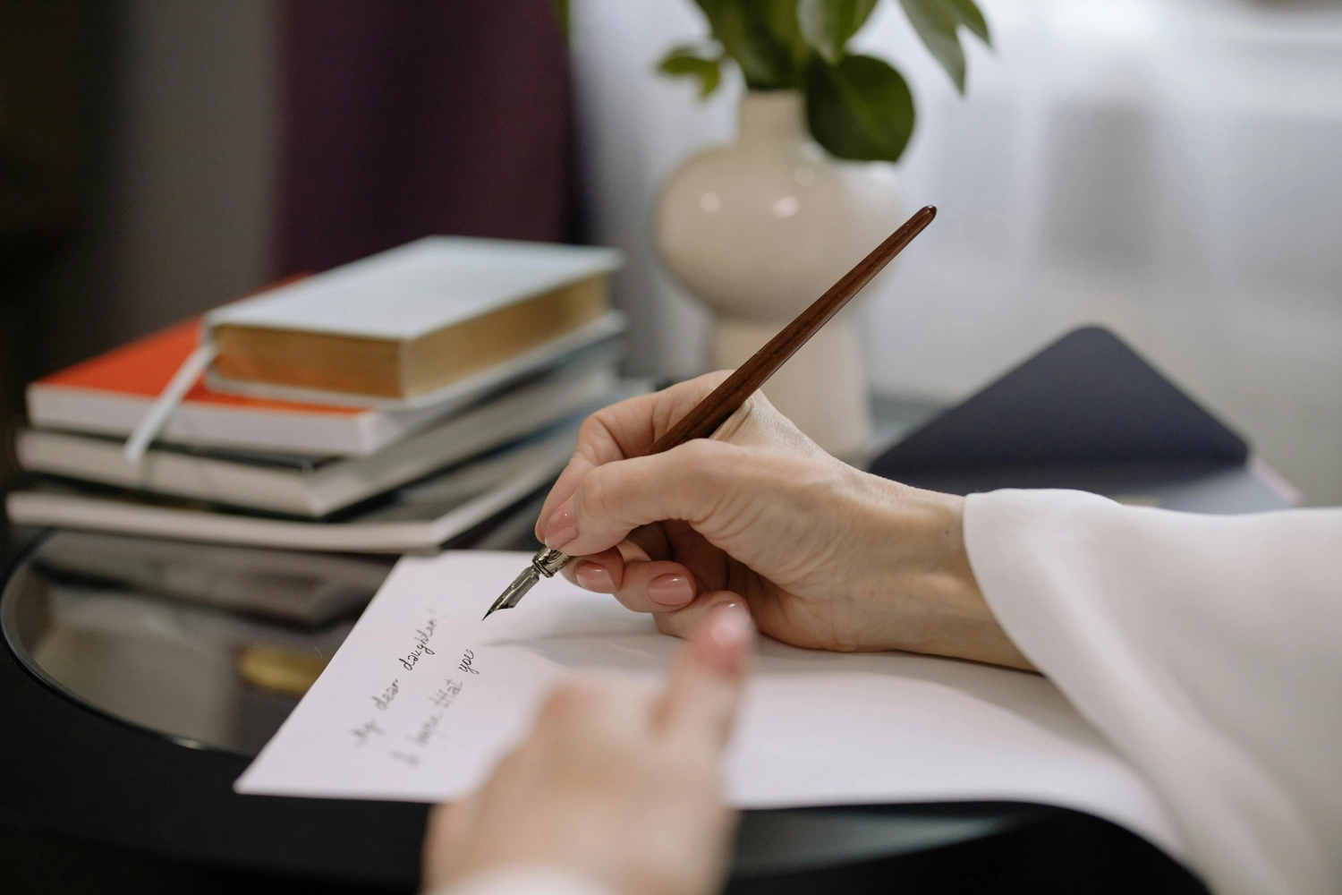 LILIAN ALEXANDRA – Autorin – Eine Frau schreibt auf einem Blatt Papier